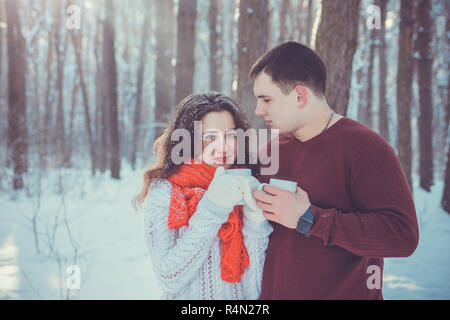 Junges Paar Getränke Tee im Winter Wald. Junge Menschen, die eine gute Zeit im Freien zusammen Stockfoto