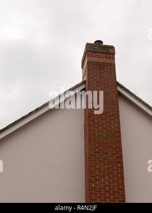 Ein großer Schornstein an der Seite eines Hauses mit einem Himmel Hintergrund und weiße Kugeln und Dach lange Hohe großen Ziegelsteinen private gemütliche Stockfoto