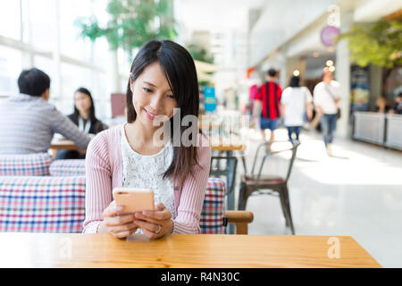 Frau, die Nutzung von Mobiltelefonen im Restaurant Stockfoto