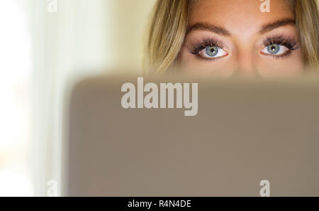 Die Augen der jungen Frau mit Laptop Stockfoto