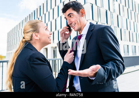 Flirt am Arbeitsplatz - Frau necken Mann Stockfoto