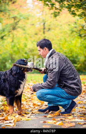 Mann werfen Stick für seinen Hund abrufen Stockfoto
