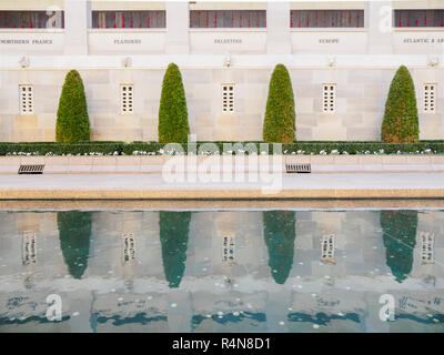 Formgehölze durch einen reflektierenden Pool an Australian War Memorial in Canberra, Australien Stockfoto