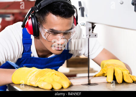 Asiatische Tischler oder Arbeiter auf Säge mit Holz Stockfoto