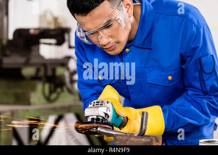 Arbeitnehmer arbeiten auf Metall mit Schleifer Werkzeug Stockfoto