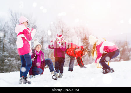 Familie Spielen im Schnee in Kampf mit Schneebällen Stockfoto