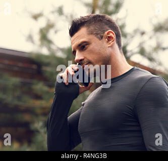 Denken casual ernster Mann in Problem zu Fuß auf die Straße und Gespräch am Handy auf Sommer Hintergrund. Getönten Closeup Portrait Stockfoto