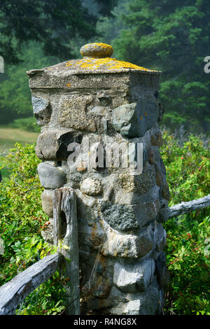 Verwitterter Stein Säule, Teil eines alten Zaun grenzt an die Ufer Pfad in Bar Harbor, Maine, USA. Stockfoto