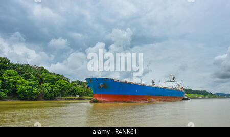 Ein großes Frachtschiff macht seinen Weg durch den Panamakanal Wasserstraßen, auf jeder Seite zwischen den Schleusen mit grünen Wald flankiert wird. Stockfoto