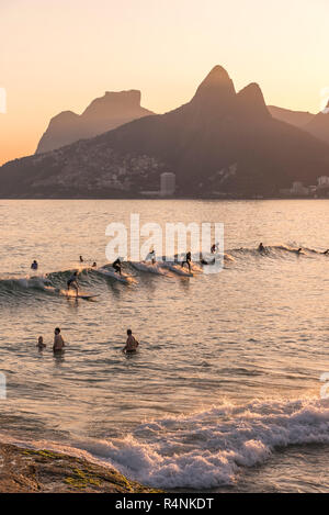 Gruppe von Surfer reiten Welle im Meer bei Sonnenuntergang, Strand, Ipanemaâ Rioâ deâ Janeiro, Brasilien Stockfoto