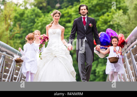 Hochzeit paar mit Blume Kinder auf Brücke Stockfoto