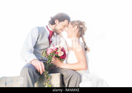 Brautpaar küssen auf Feld nach Hochzeit Stockfoto