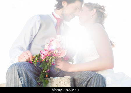 Brautpaar küssen auf Feld nach Hochzeit Stockfoto