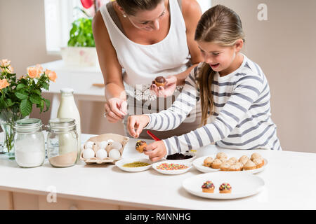 Schwangere Mutter und ihre kleine Tochter Backen zusammen Stockfoto