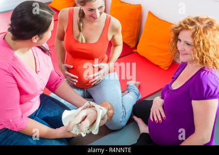 Hebamme erklärt Geburt für schwangere Frauen während der Geburt liegenden Klasse Stockfoto