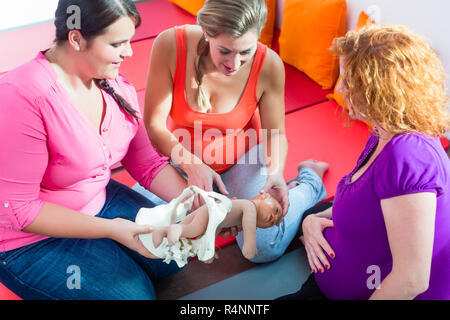 Hebamme erklärt Geburt für schwangere Frauen während der Geburt liegenden Klasse Stockfoto