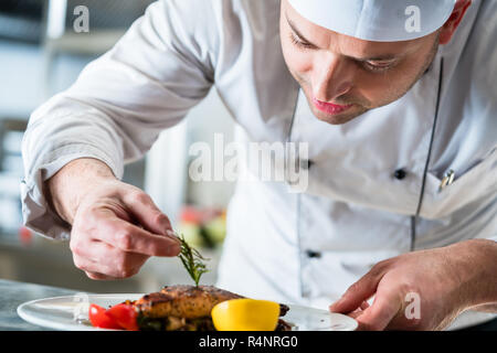 Koch garnieren das Essen auf den Teller zu füllen Stockfoto