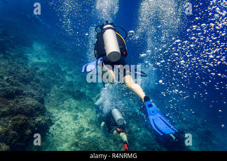 Luftblasen, die sich aus Taucher an Korallenriff unter Wasser Stockfoto