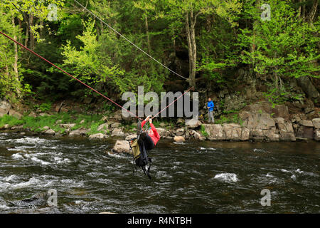 Kletterer Verfahren über die Au Sable River, um Zugang zum Klettern einer Route auf Moss Klippe über Wilmington Kerbe, Adirondack Mountains, New York State, USA Stockfoto