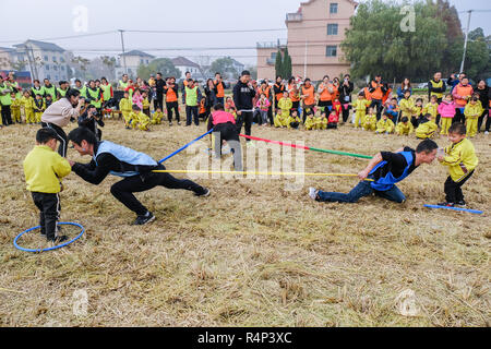 Changxing, der chinesischen Provinz Zhejiang. 28 Nov, 2018. Eltern und Kinder in einem Reisfeld Freizeitgestaltung in Changxing, im Osten der chinesischen Provinz Zhejiang, Nov. 28, 2018. Die Veranstaltung wurde durch einen lokalen Kindergarten am Mittwoch das Bewusstsein für Fitness zu erhöhen und Eltern-Kind-Interaktion fördern Kinder organisiert. Credit: Xu Yu/Xinhua/Alamy leben Nachrichten Stockfoto