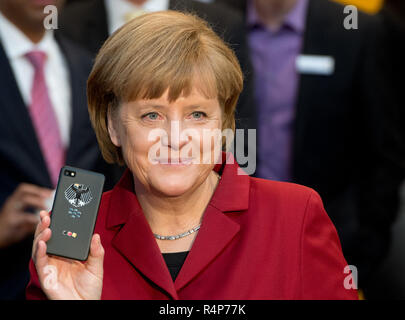 Hannover, Deutschland. 05 Mär, 2013. Bundeskanzlerin Angela Merkel (CDU) wird bei Secusmart stand Tour während der Eröffnung der weltweit größten Computermesse CeBIT mit ein Bug sein Blackberry. (Dpa' IT-Messe Cebit wird eingestellt "Vom 28.11. 2018) Credit: Julian Stratenschulte/dpa/Alamy leben Nachrichten Stockfoto