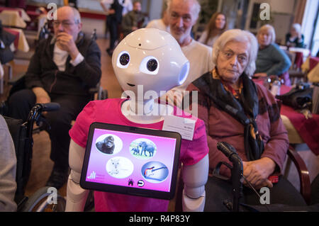 Frankfurt am Main, Deutschland. 28. Nov 2018. Der humanoide Roboter "Peppa' steht in der Mitte der Bewohner eines Alten- und Pflegeheims bei einer Informationsveranstaltung. Im Rahmen eines Projektes an der Fachhochschule Frankfurt, die Schüler wollen, um zu erfahren, was die Senioren aus dem Roboter wollen, so dass Sie vielleicht eines Tages in Altenheimen verwendet werden. Foto: Boris Roessler/dpa Quelle: dpa Picture alliance/Alamy leben Nachrichten Stockfoto