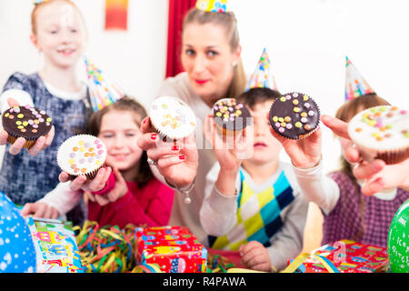 Kinder zeigen muffin Kuchen zum Geburtstag Stockfoto