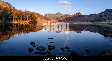 Spiegel - wie Reflexionen der Langdale Pikes in Blea Tarn auf Morgen eine kalte, klare Winter Stockfoto