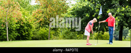 Ältere Frau und Mann spielt Golf Putting auf Grün Stockfoto
