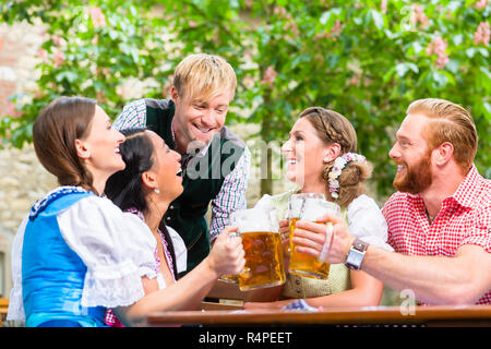 Freunde anstoßen im Biergarten Stockfoto
