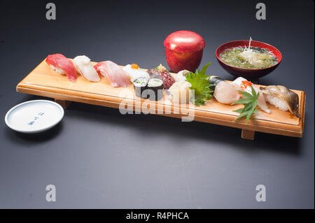 Sushi-Mahlzeit mit Thunfisch, Reis, gebratener Fisch, Tintenfisch, Maki und Seetang-Suppe Stockfoto