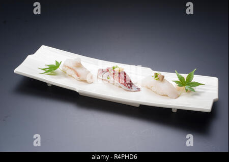 Sushi-Mahlzeit mit Thunfisch, Reis, gebratener Fisch, Tintenfisch, Maki und Seetang-Suppe Stockfoto