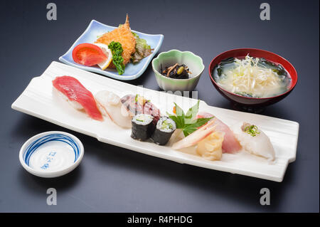 Sushi-Mahlzeit mit Thunfisch, Reis, gebratener Fisch, Tintenfisch, Maki und Seetang-Suppe Stockfoto