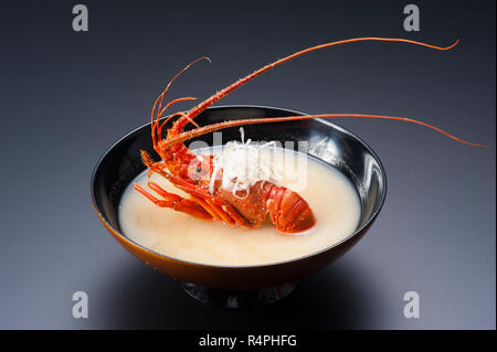 Hummersuppe mit ganz roten Garnelen in schwarz Schüssel Stockfoto