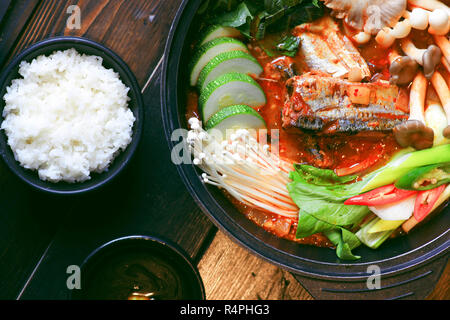 Hot Pot Makerel Fisch mit Pilzen, Kohl, Gurken und Reis am Tisch zubereitet Stockfoto