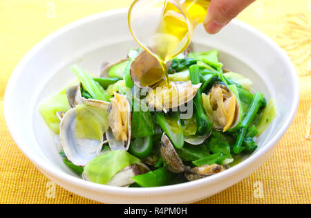 Gedämpfte Muscheln mit Gemüse und Öl in Schüssel weiß Stockfoto