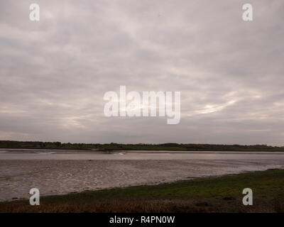 Bei Ebbe Sommer Himmel Einbruch der Dunkelheit grau Wolken Stimmung und Rottönen mit River fließt in Wivenhoe Essex uk England Stockfoto