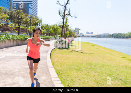 Junge Frau mit smart Watch in Park Stockfoto