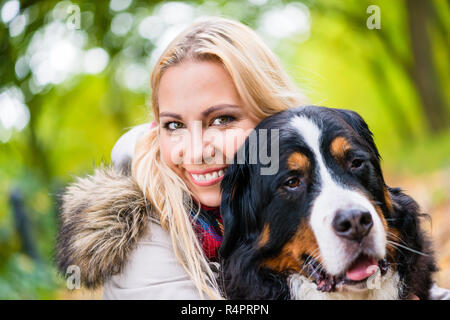 Frau Kuscheln mit Berner Sennenhund Stockfoto