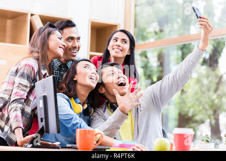 Kreatives Team von fünf begeisterte Mitarbeitende, die eine selfie Foto Stockfoto