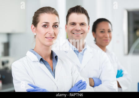 Gruppe von Wissenschaftlern mit Handschuhe und Kleider im Labor Stockfoto