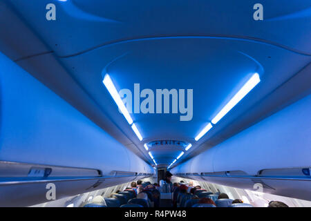 Innenraum der Flugzeug voller sitzende Fahrgäste im Flug mit EXIT Schild deutlich sichtbar Stockfoto