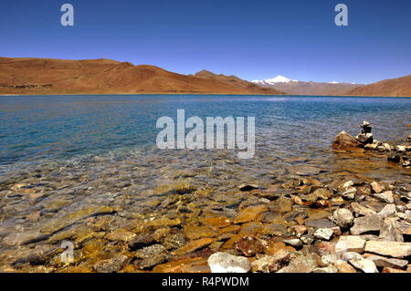 Steinigen Ufer mit dem klaren Wasser des Blauen Sees im Hochland von Tibet Stockfoto