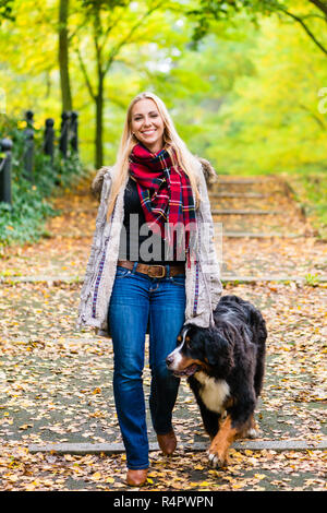 Frau gehen der Hund an der Leine im Park Stockfoto