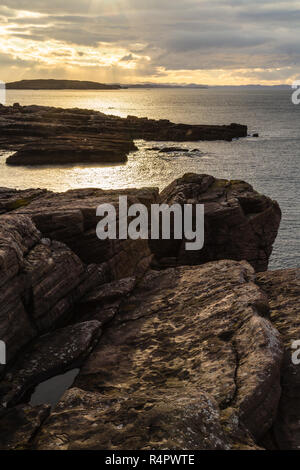 Gefilterte Sonnenlicht auf Felsen am Rieff, Cogach, North-West Highlands von Schottland. Stockfoto