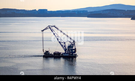 Schwimmkran auf dem Hintergrund der Insel russische Segel durch den Bosporus Osten in der Fernöstlichen Stadt Wladiwostok. Stockfoto