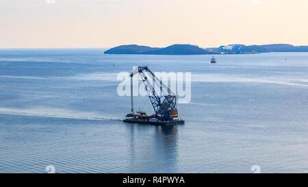 Schwimmkran auf dem Hintergrund der Insel russische Segel durch den Bosporus Osten in der Fernöstlichen Stadt Wladiwostok. Stockfoto