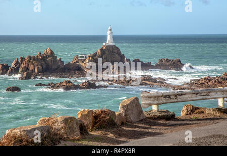 La Corbière Lighthouse, Jersey. Der Leuchtturm befindet sich auf einem Felsen, die eine Flutwelle Insel. Einen Damm links den Leuchtturm bei Ebbe an der Küste. Stockfoto