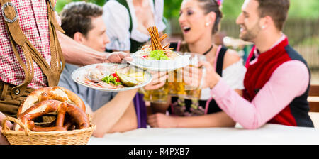 Kellner servieren Essen im Bayerischen Biergarten Stockfoto