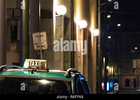 Taxi Schild auf dem Dach eines Autos in der Nacht in Lissabon. Stockfoto